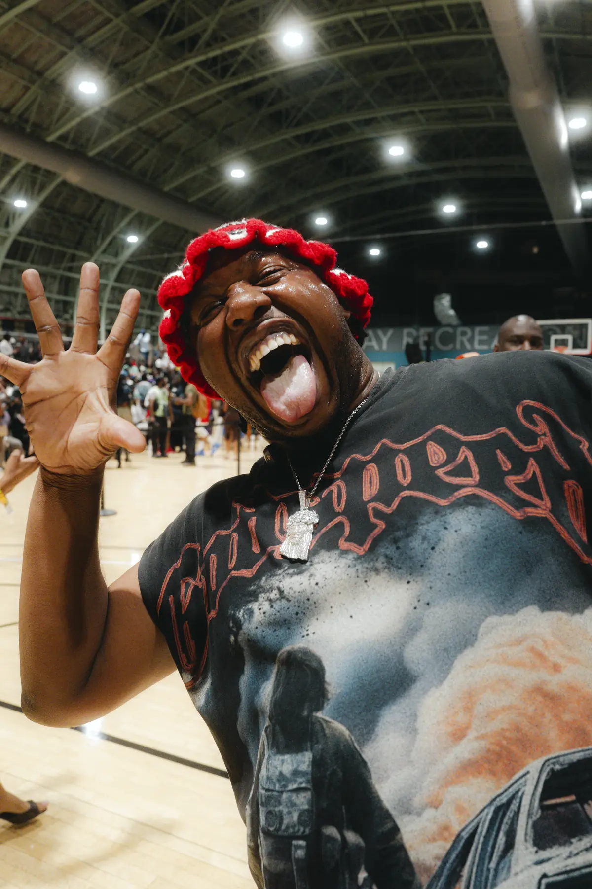 A fan in a red knit hat celebrating on the court