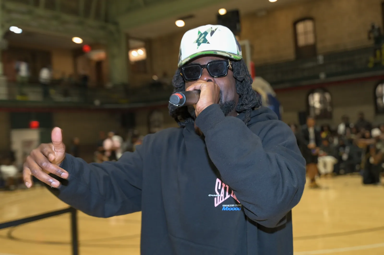 A performer rapping into a microphone on the court